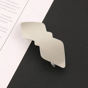 Détail macro d'une pince à cheveux en métal brossé argenté au design géométrique