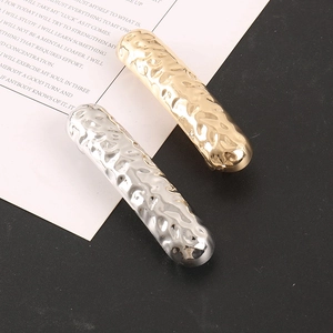 Detailed view of gold and silver hair clips with a hammered textured metal surface