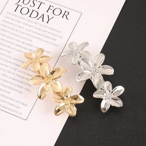 Vue détaillée des pinces à cheveux à fleurs plaquées or et argent avec pétales texturés