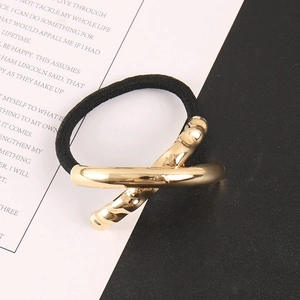 Close-up of golden geometric X-shaped alloy buckle on high-elastic black hair tie