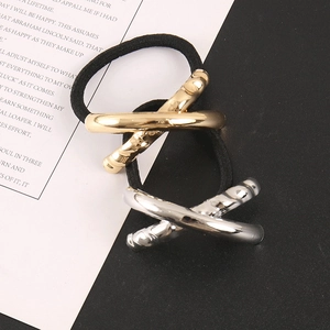 Close-up of gold and silver metal cross hair ties with elastic black bands