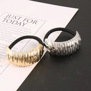 Detail of crescent metal hair ties in gold and silver with textured surface finish