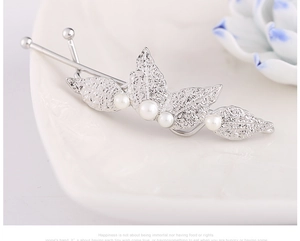Close-up of silver leaf hair clip with white faux pearls and detailed vein textures