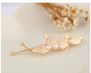 Detailed view of a golden metal leaf hair clip with elegant pearls and leaf vein texture