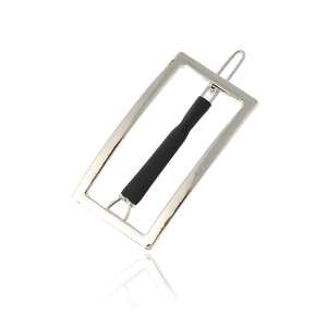 Detail view of a minimalist silver geometric rectangular hair clip with black accent