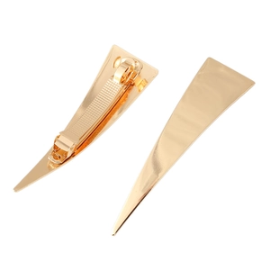 Detailed view of golden triangular hair clips with smooth metallic finish and back clips