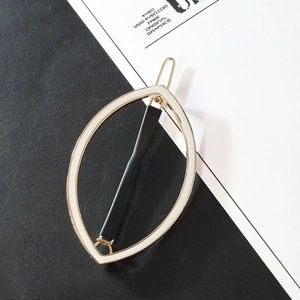 Detail view of a hollow marquise hair clip in gold alloy with a textured black inlay