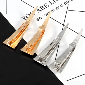 Close-up of sleek gold and silver metal triangle hair clips with high-gloss finish