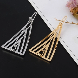 Minimalist geometric triangle hair clips in gold and silver finish with striped metal texture