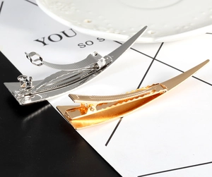 Close-up of sleek gold and silver geometric hair pins with polished metallic finish