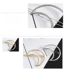 Détail de la pince à cheveux lune avec bords lisses et placage or et argent