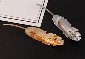 Detailed back view of metallic leaf hair clips showing the spring clasp mechanism