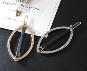 Set di fermagli per capelli ovali cavi in metallo oro e argento su superficie nera