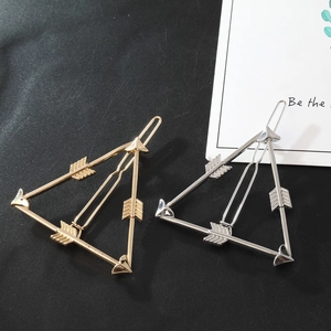 Close-up of geometric triangle hair clips with arrow design in gold and silver finish