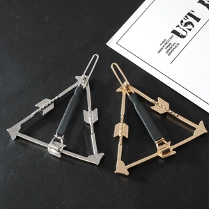 Detail of minimalist gold and silver arrow-shaped hair clips with a metallic finish