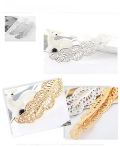 Macro detail of镂空metal leaf hair clip with intricate vein texture in gold and silver