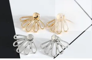 Detailed close-up of hollow five-petal lotus stud earrings in gold and silver finish