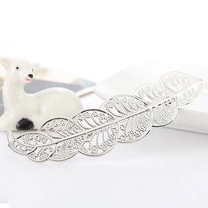 Elegant silver metal leaf hair clip with hollow design for women on a decorative plate