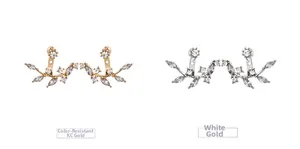 Detail of leaf-shaped earrings in gold and platinum finishes with white zircon stones