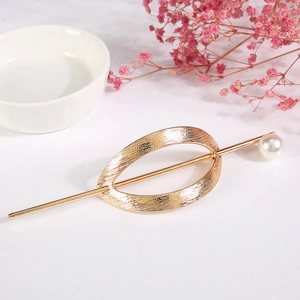 Vue détaillée d'épingle à cheveux dorée avec motif ovale évidé et perle blanche élégante