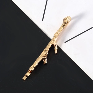 Minimalist golden tree branch hair clip with textured metallic finish for women