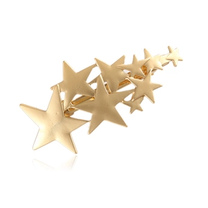 Detail of the golden metallic star-shaped hair clip with smooth polished finish
