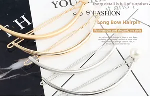 Detail of elegant gold and silver long bow hairpins featuring polished alloy and pearls