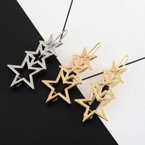 Macro detail of metallic star hair clips set in silver, champagne gold and bright gold