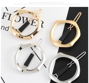 Detail view of geometric hair clips in gold and silver with polished and matte finishes