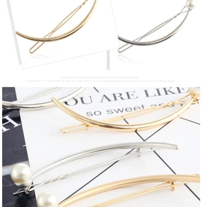 Detail of elegant gold and silver crescent hair clips with pearl accent on display card