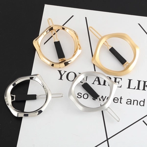 Macro shot of a four-piece geometric hair clip set in gold and silver polished finishes