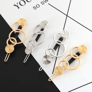 Minimalist geometric gold and silver triple ring hair clips in 45-degree angle view