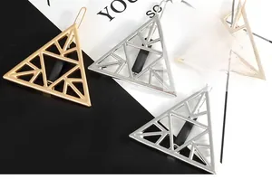 Detailed view of hollow geometric triangle hair clips in metallic gold and silver finish