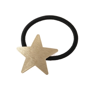 Vue détaillée de l'élastique à cheveux noir avec pendentif étoile dorée à texture brossée