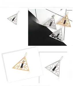 Detail view of hollow geometric triangle hair clips in gold and silver finish