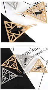 Close-up of geometric hollow triangle hair clips in gold and silver finish with mesh detail