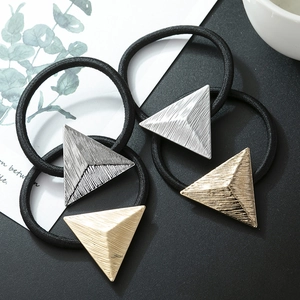 Detail of matte gold and silver triangle hair ties with brushed metal texture and black elastic