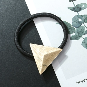 Detail of high-elastic black hair tie with textured golden triangle geometric charm