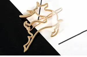 Detail shot of a golden hollow deer-shaped hairpin with polished metallic finish