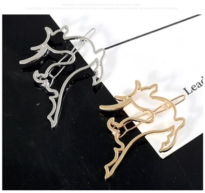 Close-up of hollow cat-shaped hair clips in polished gold and silver metallic finishes