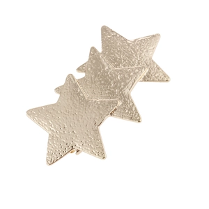 Detail of three hammered gold star hair clips with textured finish and metal clip
