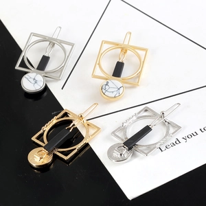 Detail view of gold and silver geometric hair clips with marble turquoise inlay