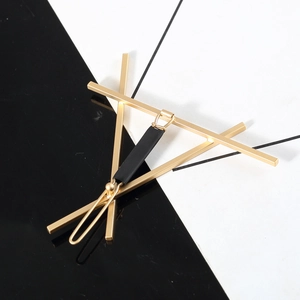 Close-up of minimalist gold and black geometric hair clip on a modern background
