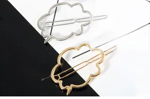 Close-up of cloud-shaped hollow metal hair clips in polished gold and silver finishes