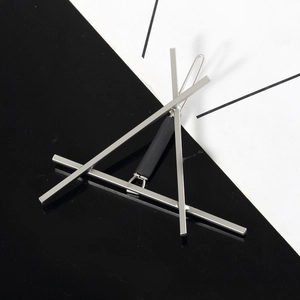 Detail view of a minimalist silver geometric triangle hair clip with a black cylindrical accent