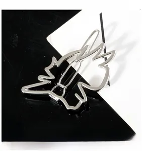 Detailed close-up showing the hollow silver dinosaur hair clip with a polished alloy finish