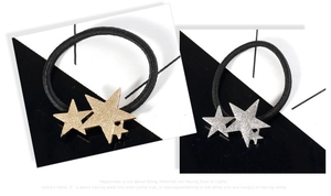 Detail of star-shaped hair ties with matte metallic finish in gold and silver colors