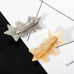 Minimalist interlocking star hair clips in gold and silver finish with brushed metal texture