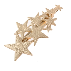 Detail of golden five-point star hair clip with textured hammered finish on a white background