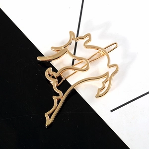 Minimalist golden metal deer hair clip with hollow geometric reindeer design on black background
